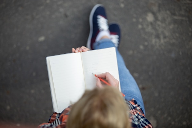 Student Dziewczyna Pisania Ołówkiem W Notesie