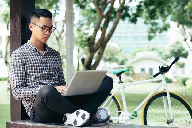 Student korzysta z laptopa na zewnątrz