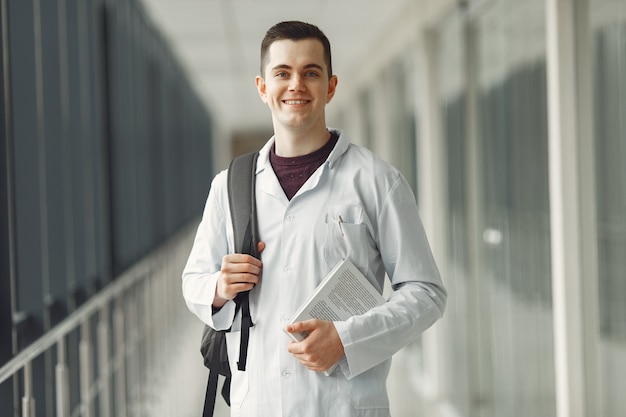 Student medycyny z plecakiem stoi w nowoczesnej klinice
