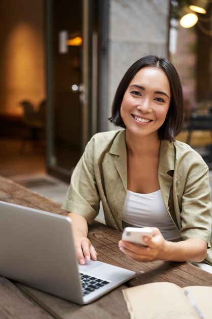 Student studiujący siedząc z laptopem w kawiarni pracujący zdalnie za pomocą laptopa