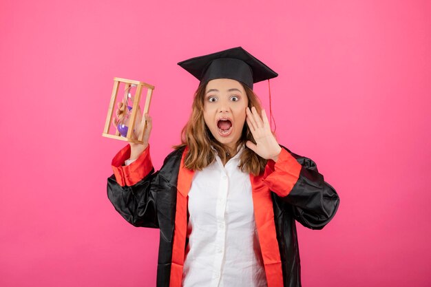 Studentka trzymająca piaskowy zegar i krzycząca. Zdjęcie wysokiej jakości