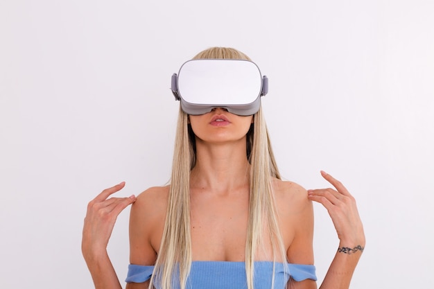 Bezpłatne zdjęcie studio fotografii młodej atrakcyjnej kobiety w ciepłym niebieskim modnym garniturze w okularach wirtualnej rzeczywistości na białym