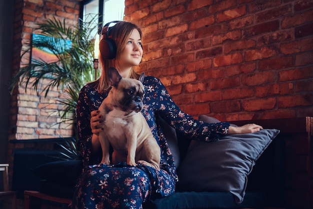 Studio portret atrakcyjna szczęśliwa blondynka w pokoju z wnętrzem na poddaszu.