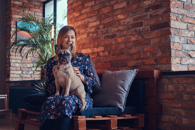 Studio portret atrakcyjna szczęśliwa blondynka w pokoju z wnętrzem na poddaszu.