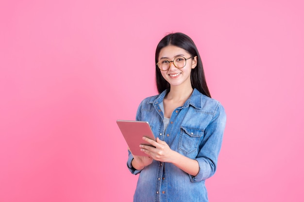 styl życia ludzi biznesu Piękna ładna dziewczyna kobieta trzyma komputer tablet inteligentny telefon na różowo