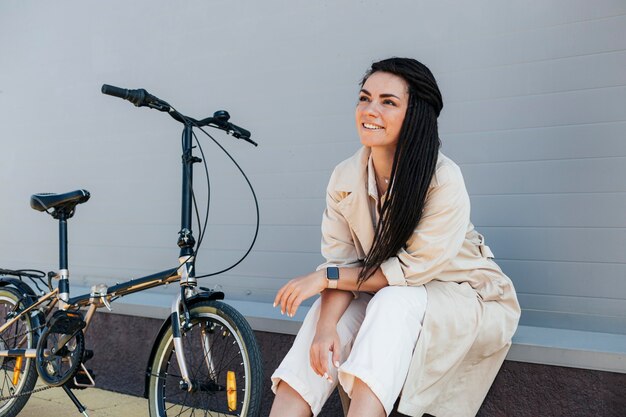 Stylowa dorosła kobieta pozuje z ekologicznym rowerem