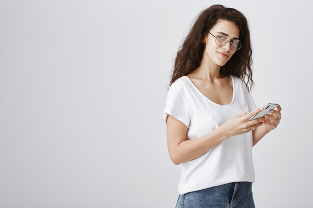 Stylowa, przystojny kobieta w okularach przy użyciu telefonu komórkowego