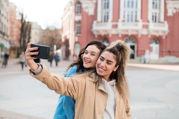 Bezpłatne zdjęcie stylowi nastolatkowie biorący selfie na zewnątrz