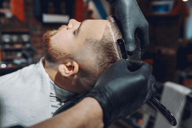 Stylowy mężczyzna siedzi w zakładzie fryzjerskim