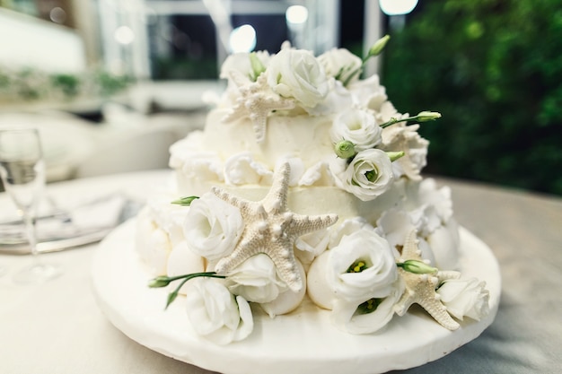Stylowy tort weselny ozdobiony srebrnymi seastarami