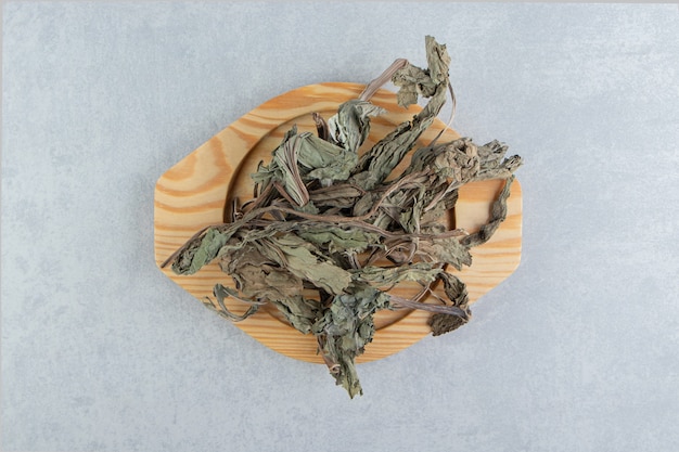 Suche liście herbaty na drewnianym talerzu