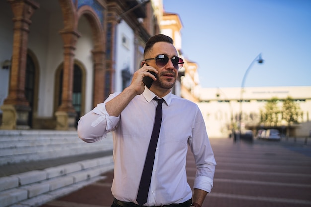 Sukcesy Młody Biznesmen Rozmawia Przez Telefon W Formalnym Stroju Z Okularami Przeciwsłonecznymi