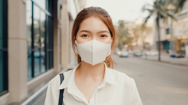 Sukcesy młodych azjatyckich bizneswoman w strojach biurowych mody na sobie maskę medyczną uśmiechnięty na ulicy