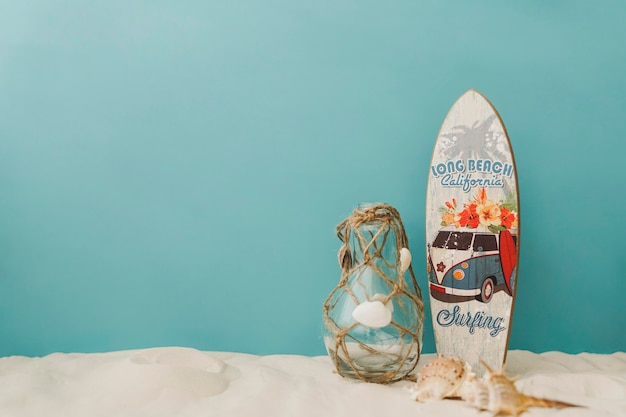 Surfboard, mollusks i butelka na niebieskim tle