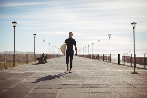 Surfer chodzenie z deską surfingową