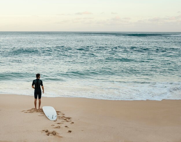 Surfer człowiek patrząc na morze poziome długie ujęcie