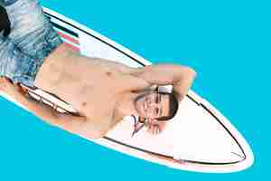 Bezpłatne zdjęcie surfer mężczyzna pozowanie, uśmiechając się