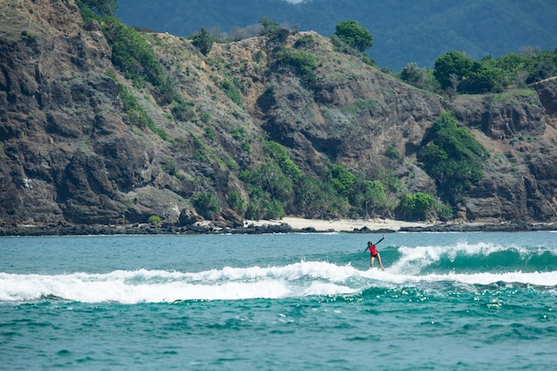 Surfer na błękitnej fali.