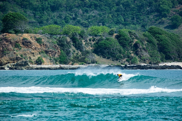 Surfer na błękitnej fali.