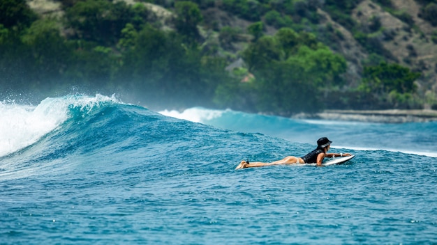 Surfer na błękitnej fali.