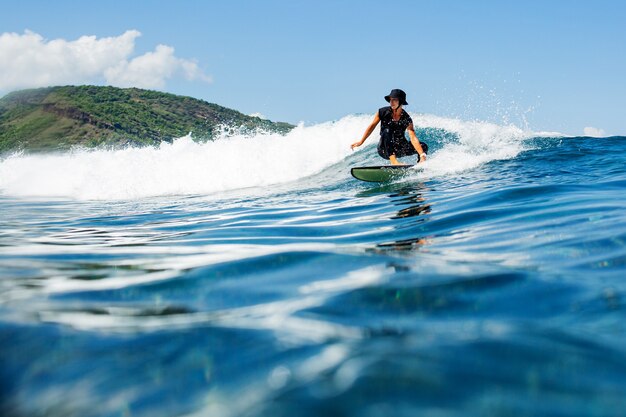 Surfer na błękitnej fali.