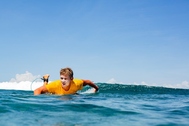 Surfer na błękitnej fali.