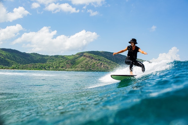 Surfer na błękitnej fali.