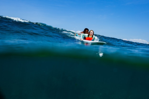 Surfer na błękitnej fali.