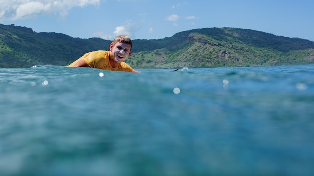 Surfer na błękitnej fali.