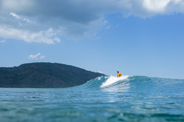 Surfer na błękitnej fali.