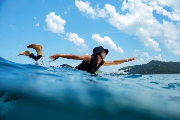 Surfer na błękitnej fali.