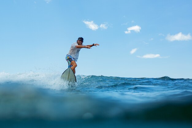 Surfer na błękitnej fali.