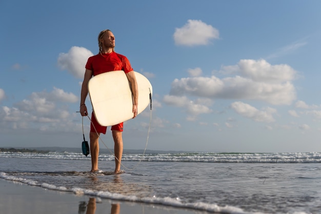 Surfer spacerujący po plaży. Bali