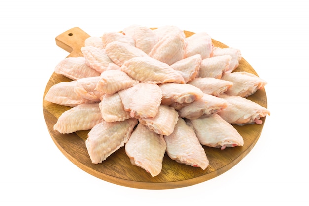 Surowy kurczaka mięso, skrzydło na drewnianej tnącej desce i talerzu lub