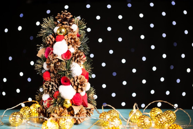 Świąteczna mini choinka i dekoracja światła na świątecznym świetle bokeh. Dekoracja i wakacje. Sezonowe i noworoczne