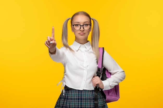 Bezpłatne zdjęcie Światowy dzień książki uczennica blondynka z gestem ręki znak stop w okularach