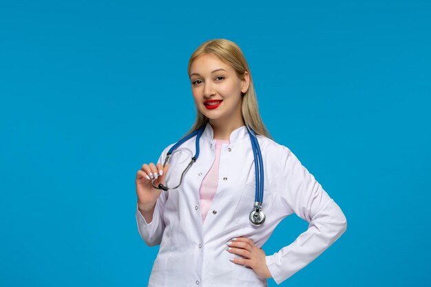 Światowy Dzień Lekarza Śliczna blond młoda lekarka ze stetoskopem w fartuchu medycznym