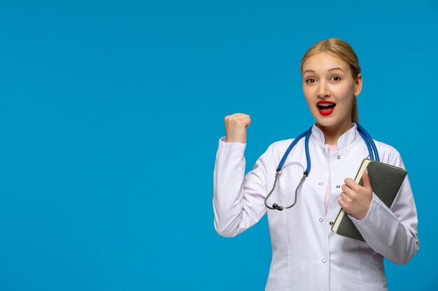 Światowy dzień lekarza szczęśliwy lekarz pokazujący pięść zwycięstwa stetoskopem w fartuchu medycznym