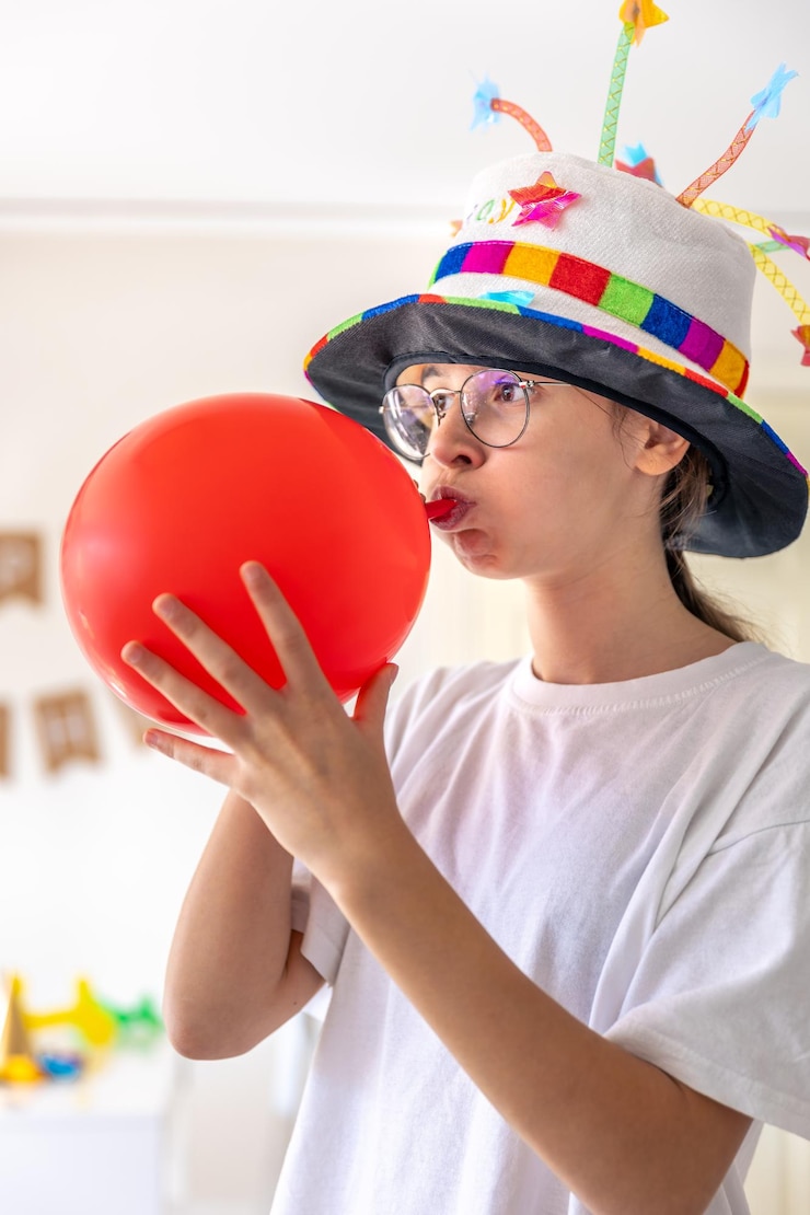 Bezpłatny plik Zdjęcie świętowna dziewczyna napełnia balon na swoje urodziny koncepcja urodzinowa