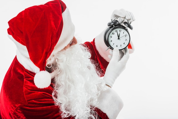 Bezpłatne zdjęcie Święty mikołaj patrzeje zegar w rękach