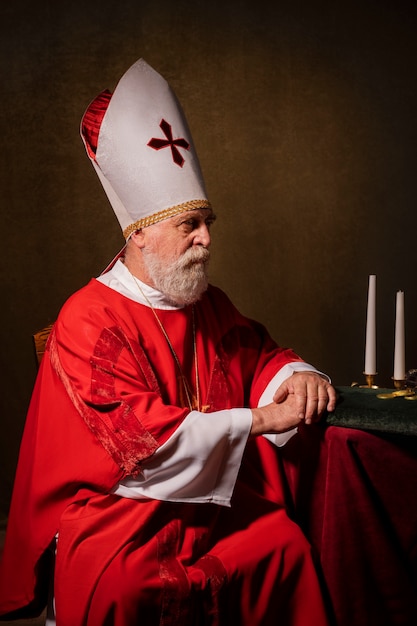 Bezpłatne zdjęcie Święty mikołaj siedzący na krześle z boku