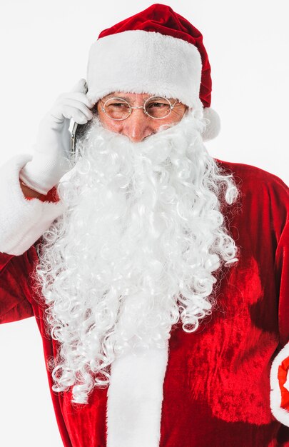 Święty Mikołaj w kapeluszu rozmawia przez telefon