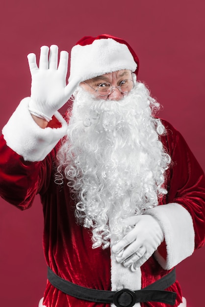 Święty Mikołaj w szkłach pokazuje powitanie gest