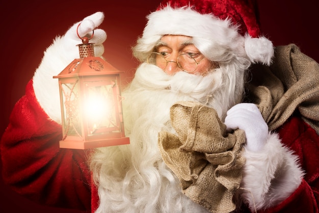 Bezpłatne zdjęcie Święty mikołaj z latarnią i worek na prezenty