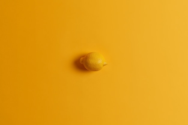 Świeża cała soczysta soczysta żółta cytryna w jednym kolorze z tłem. Tropcial cytrusowy owoc. Zdjęcia monochromatyczne. Źródło witamin. Składnik do produkcji lemoniady. Zdrowa żywność, koncepcja jedzenia