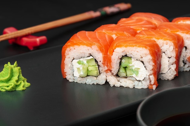 Świeża rolka sushi philadelphia podana na czarnym talerzu