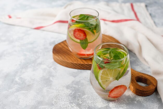 Świeża woda z limonką, truskawkami i miętą, koktajl, napój detoksykacyjny, lemoniada. Letnie drinki. Pojęcie opieki zdrowotnej.