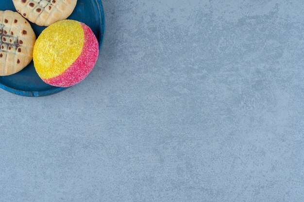 Bezpłatne zdjęcie Świeże ciasteczka brzoskwini na niebieskim talerzu nad szarym.