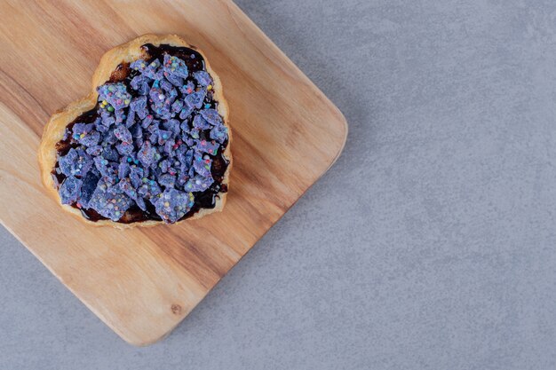 Świeże ciasteczka jagodowe domowej roboty na niebieskim drewnianym talerzu na szarej powierzchni