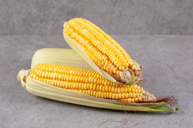 Świeże kłosy kukurydzy na szarej powierzchni